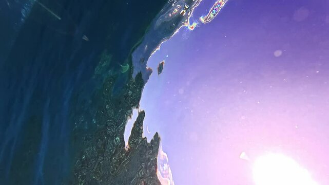 Underwater shot of blue barreling wave with silhouette of surfer in the barrel riding in slow motion. Tahiti famous surf destination for surfers, French Polynesia. 