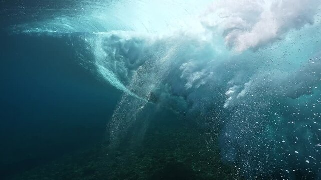 Powerful wave breaks underwater turbulence, wave crashing on the corral reef in tropical ocean. spinning vortex. powerful nature, strong wave. slow motion 4k.