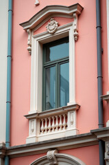 Fototapeta premium A bright pink building features a large clock on its exterior, perfect for use in illustrations about timekeeping, architecture, or whimsical scenes
