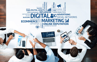 A top-down view of a diverse team collaborating on digital marketing strategies, analyzing data with laptops and charts in a modern office setting, promoting engagement and innovation. Amity