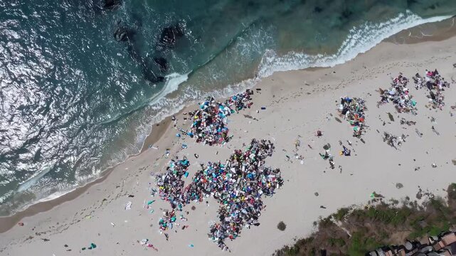 Environmental Crisis: Aerial View of Pristine Beach Contaminated with Plastic Waste. Ocean Garbage Patches Contrasting Against Blue Waters