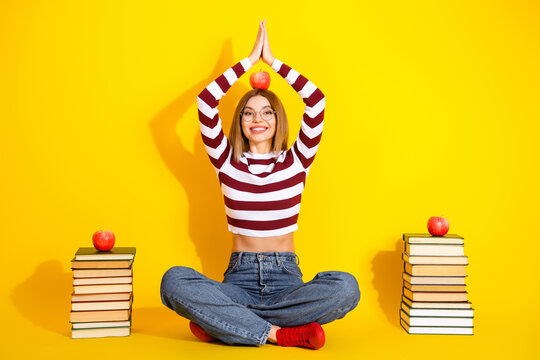 Relaxation and mindfulness portrayed by a stylish young woman in casual attire, meditating on a vibrant yellow background