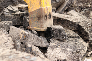 Close-up of a working jackhammer. Hydraulic hammer. Equipment. Hydraulic hammer for road repair. Hydraulic jackhammer mounted on an excavator. Parts of heavy equipment at a construction site