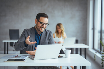 Professional Businessman in Modern Office Working Collaboratively on Laptop