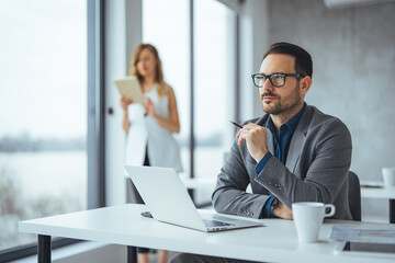 Thoughtful Businessman Planning Strategy at Modern Bright Office Desk