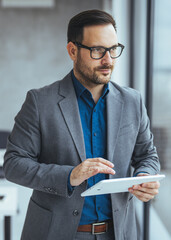 Confident Businessman Using a Tablet in a Modern Office Setting
