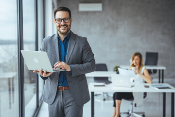 Confident Businessman Using Laptop in a Modern Office Environment