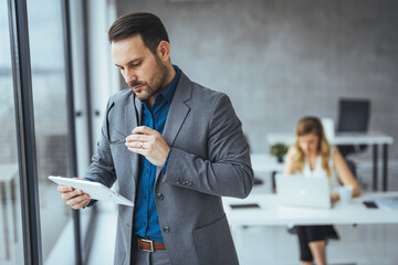 Business Professional Reviewing a Tablet in a Modern Office Setting