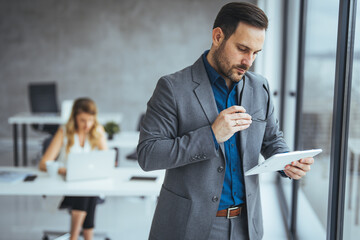 Focused Businessman Holding Documents in a Modern Office Environment