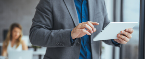 Businessman Using a Tablet in an Office Setting During a Work Meeting