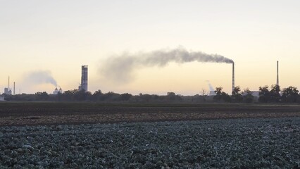 Heavy gray smoke is poured from the chimney pipes of thermal power plant. Carbon dioxide emitting...