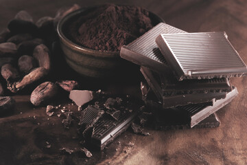 Pieces of dark chocolate on a black wooden background