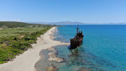 Abandoned shipwreck Dimitrios rests on a serene beach surrounded by clear blue waters in Gytheio...
