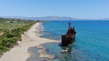 Abandoned shipwreck Dimitrios rests on a serene beach surrounded by clear blue waters in Gytheio...