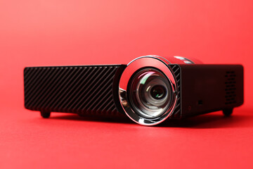 Modern video projector on red background, closeup