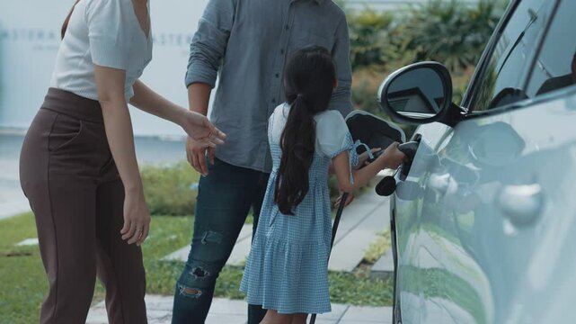 Concept of a progressive family with a home charging station for an electric vehicle, encouraging healthy and clean environment. The electric vehicle powered by sustainable, clean energy technology.