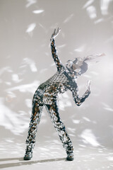 Mirror dancer performing in sparkling costume on white background