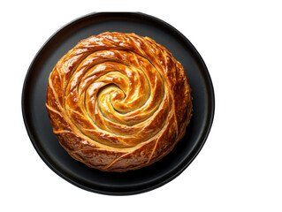 Fototapeta premium Spiral Pastry on Black Plate: A golden-brown spiral pastry, baked to perfection, sits on a dark slate plate, showcasing its intricate design and appealing texture.