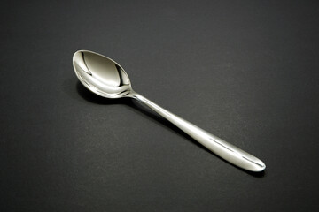 silver spoon isolated on black background closeup view 
