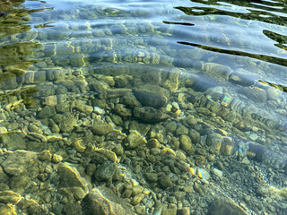 Pebbles and stones in transparent sea water.