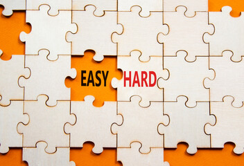 Fototapeta premium Easy or Hard symbol. Concept word Easy or Hard on wooden puzzle. Beautiful orange background. Business and Easy or Hard concept. Copy space