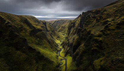 A view from above of a narrow and deep gorge with steep green slopes, along the bottom of which a river winds.