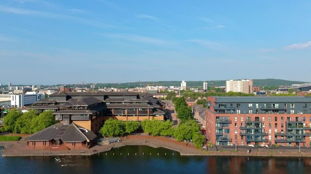 Aerial drone footage of the Atlantic Wharf neighbourhood in Cardiff, Wales flying above the Bute East Dock. Slow motion parallel tracking shot moving left to right above the dock.