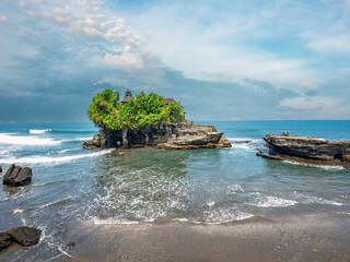 Across from a black sand beach and built on a rock formation, the Tanah Lot Sea Temple brave the...