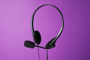 Headset with microphone in air on purple background