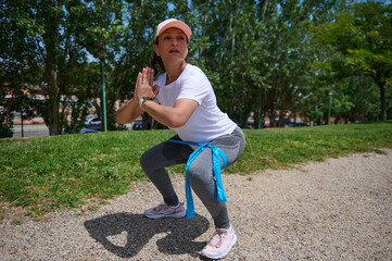 Woman Performing Outdoor Exercise Squat in a Scenic Park Setting