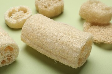 Natural loofah sponges on green background, closeup