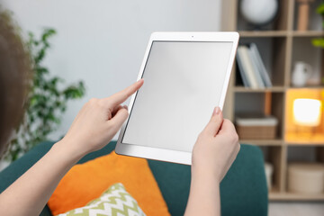Woman with modern tablet at home, closeup