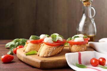 Tasty sandwiches with mozzarella cheese, tomatoes and basil on wooden table, closeup