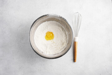 Flour, eggs, whisk on light table, top view, copy space