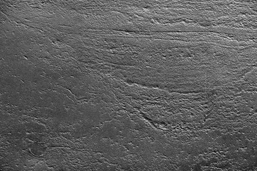 Closeup of an uneven black painted surface. The rough abstract texture for industrial backgrounds