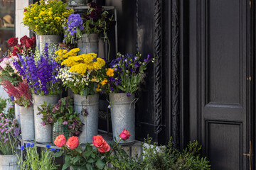 Fresh cut flowers in metal buckets outside a shop for bouquet