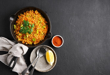 Bowl with red lentil with leek on black background. Vegan cuisine. top view , copy space