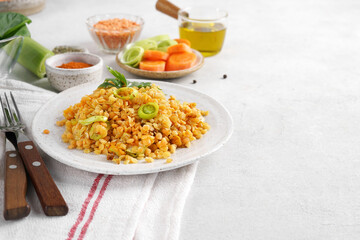 Red lentil dish with leek and carrot. Vegetarian cooking, copy space