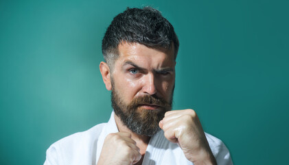 Karate man in fighting stance. Male karate fighter practices punches during karate training....