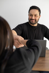 Fototapeta premium Man and woman shake hands firmly, symbolizing trust, agreement, and the successful closure of a professional business negotiation or partnership.