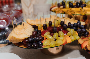 Elegant Fruit Platter Display: Cantaloupe, Grapes, Skewers, Golden Tones, Party Appetizers, Catering Setup