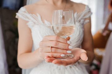 Elegant Bride Holding a Glass of Water, Wedding Celebration, White Lace Dress, Close-up Shot