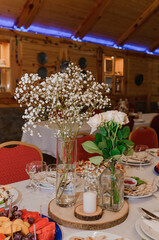 Rustic Wedding Table Setting: Baby's Breath, Roses, Wood Decor, Red Chairs, Cozy Venue
