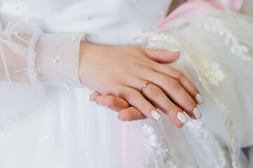 Romantic Wedding Moment: Woman&rsquo;s Hand with Rose Gold Ring on Wedding Dress, Pearl Details, Soft Focus, Pink Tones.