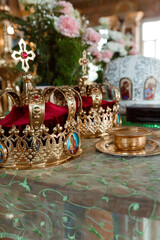 Orthodox Coronation Ceremony: Golden Crowns, Red Velvet Cushions, and Religious Symbols in a Lavishly Decorated Church Interior