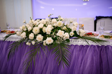 Luxurious Wedding Table Centerpiece with White Roses, Purple Tablecloth and Elegant Floral...