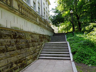 Stone stairway leading upward through lush green foliage creating mysterious pathway in urban park setting