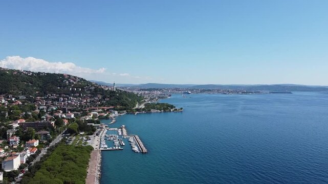 A stunning drone view of Trieste from Barcola, showcasing the city's coastline, historic buildings, and Adriatic charm under a clear northern Italian sky.