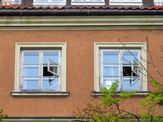 Traditional European residential building facade with white-framed windows and terracotta colored walls