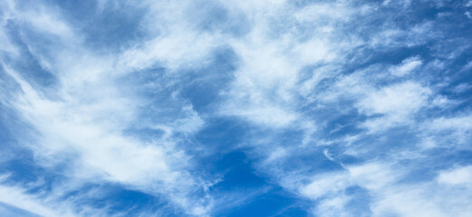 Blue sky with Wispy cirrus clouds, horizontal banner Abstract background. website headers, advertising layouts, ecological or environmental presentation